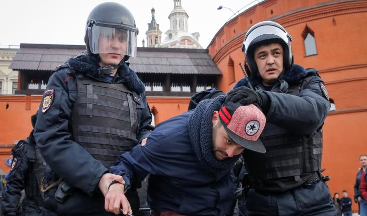 مسؤولو أمن روس يعتقلون أحد ناشطي المعارضة في موسكو أمس (رويترز)