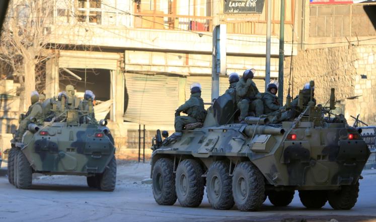 جنود روس على متن مدرعتين في أحد شوارع مدينة حلب (رويترز)