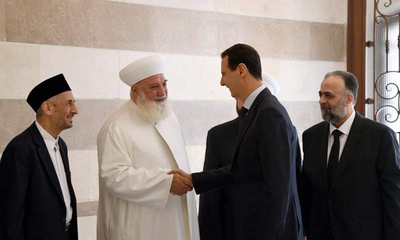 صورة عدنان أفيوني إلى جانب عدد من رجال دين مع بشار الأسد