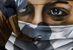 رسم جدارية للتأكيد على أهمية ارتداء الكمامة