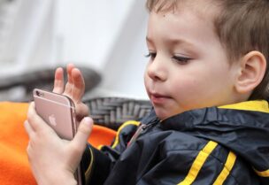 طفل يستخدم هاتف آيفون