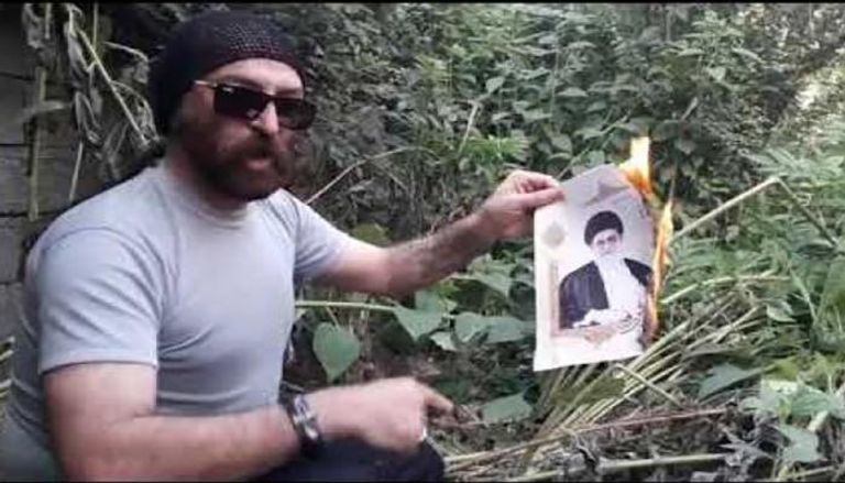 الشاعر الإيراني يحرق صورة خامنئي