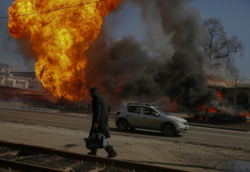 رجل يمشي بجانب حريق ناتج عن قصف في خاركيف (رويترز)