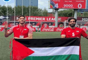 لاعبا المنتخب الفلسطيني محمد صالح ومحمود وادي يرفعان العلم الفلسطيني