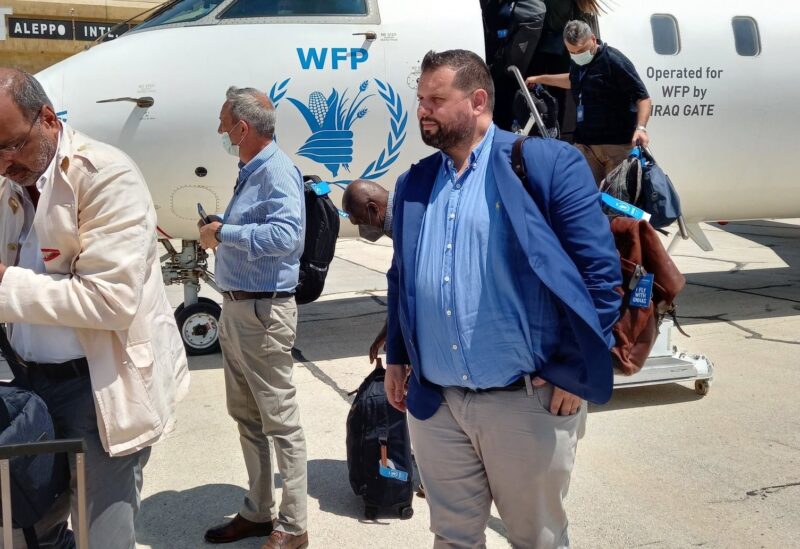 دان ستوينسكو مع عمران رضا، قرب طائرة تابعة للأمم المتحدة في مطار حلب