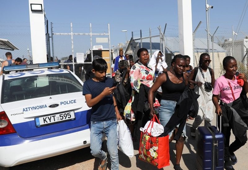 مهاجرون يغادرون مركز بورناراس في قبرص (رويترز)