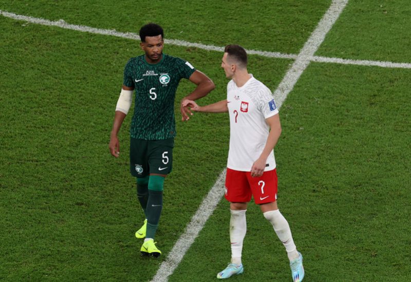 اللاعب السعودي علي البليحي يصافح أركاديوس ميليك البولندي بعد المباراة