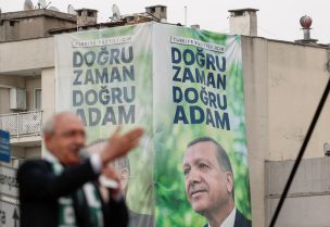 كمال كليجدار أوغلو بجانب صورة للرئيس التركي رجب طيب أردوغان