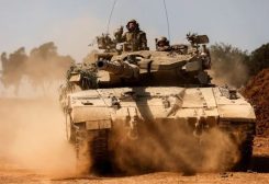عناصر من الجيش الإسرائيلي على متن دبابة قرب غزة - رويترز