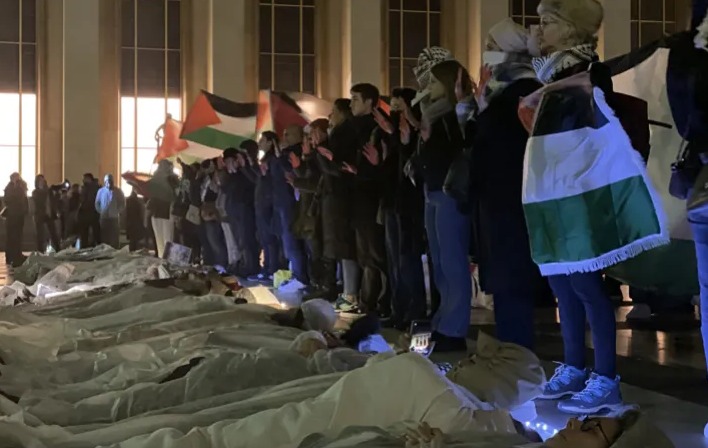 متظاهرون ارتدوا أكفانا واستلقوا على الأرض للتعبير عن ضحايا العدوان الإسرائيلي على غزة (الأناضول)