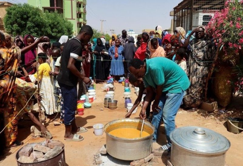 متطوع يحرك الطعام لتوزيعه على الناس في أم درمان، السودان