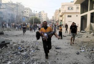 فلسطيني يركض حاملا طفلة بعد ضربة إسرائيلية في خان يونس جنوب قطاع غزة