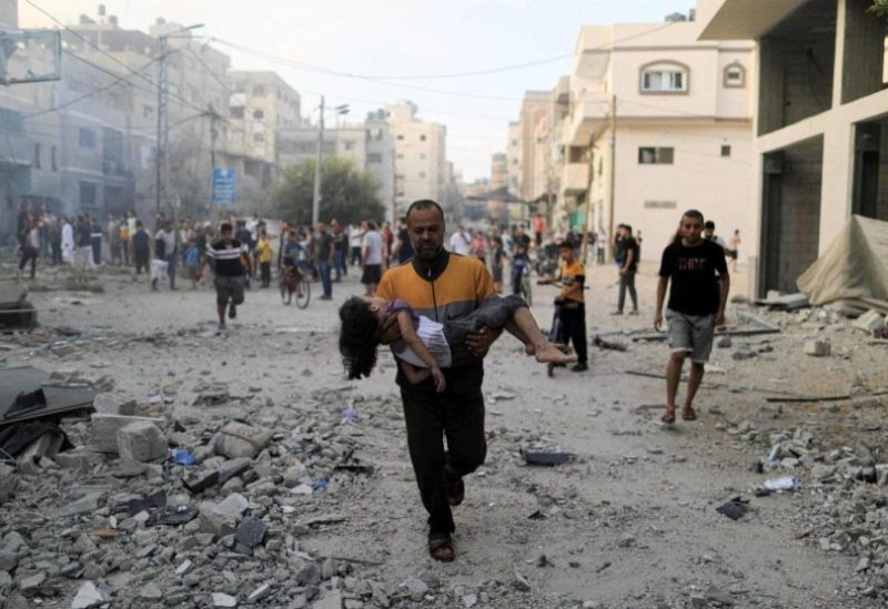 فلسطيني يركض حاملا طفلة بعد ضربة إسرائيلية في خان يونس جنوب قطاع غزة