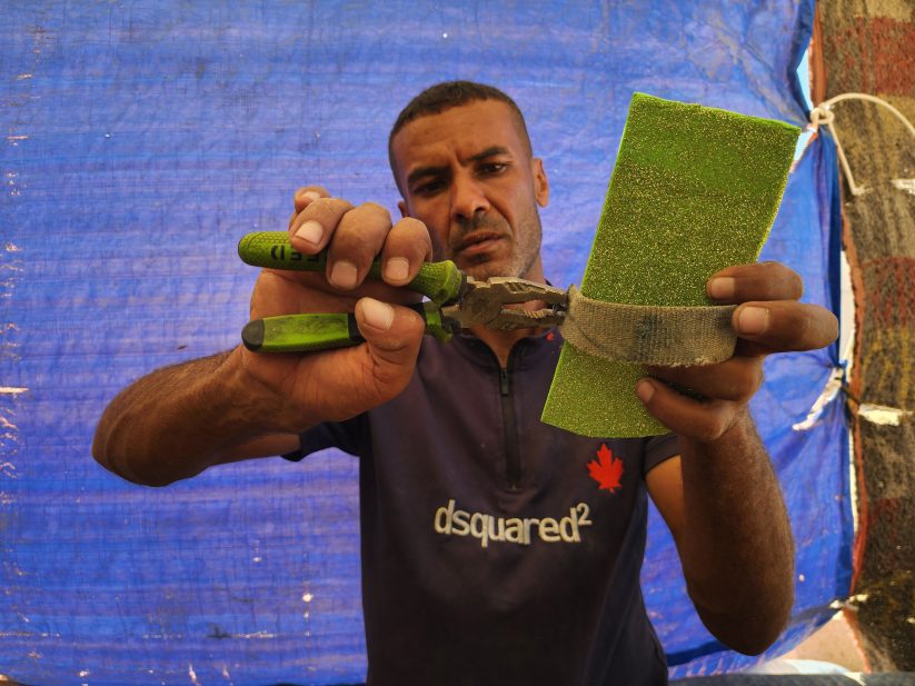 يستخدم الأب الفلسطيني أدوات بسيطة لصناعة الأحذية الخشبية (القبقاب) - الأناضول