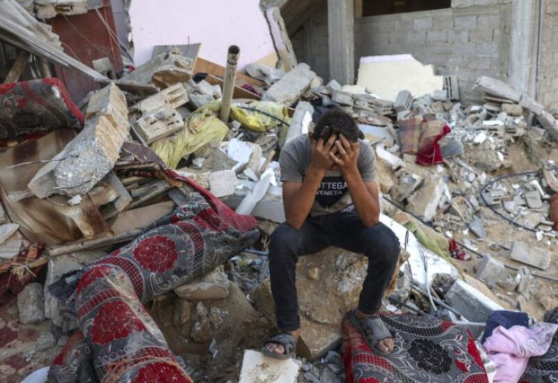 شاب فلسطيني في موقع حطام منزل بعد قصف جوي إسرائيلي على غزة