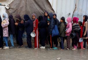 فلسطينيون يصطفون في طابور لتلقي الطعام المطبوخ في مطبخ خيري في خان يونس، جنوب قطاع غزة، 24 نوفمبر/تشرين الثاني 2024. رويترز