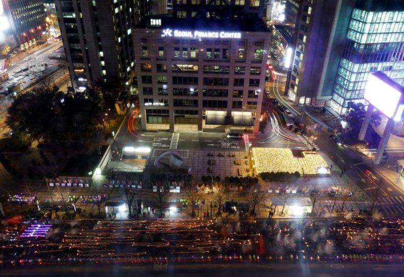 أشخاص يسيرون وهم ينظمون وقفة احتجاجية بالشموع تنديدًا بإعلان الرئيس الكوري الجنوبي يون سوك يول المفاجئ للأحكام العرفية الليلة الماضية، والذي تم التراجع عنه بعد ساعات، وللمطالبة باستقالته، في سيول، كوريا الجنوبية، 4 ديسمبر/كانون الأول 2024. رويترز