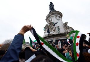 أشخاص يحملون العلم السوري الجديد يحتفلون بعد إعلان المعارضة السورية الإطاحة بالرئيس بشار الأسد في باريس، فرنسا، 8 ديسمبر/كانون الأول 2024. رويترز