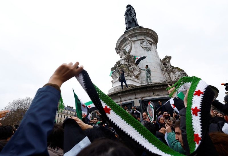 أشخاص يحملون العلم السوري الجديد يحتفلون بعد إعلان المعارضة السورية الإطاحة بالرئيس بشار الأسد في باريس، فرنسا، 8 ديسمبر/كانون الأول 2024. رويترز