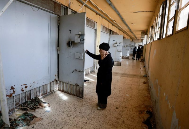 امرأة سورية تقف أمام إحدى زنازين سجن صيدنايا