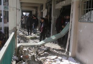 فلسطينيون يسيرون وسط الأنقاض، يتفقدون الأضرار التي لحقت بالمدرسة التي تأوي النازحين، في مدينة غزة، 14 ديسمبر/كانون الأول 2024. رويترز
