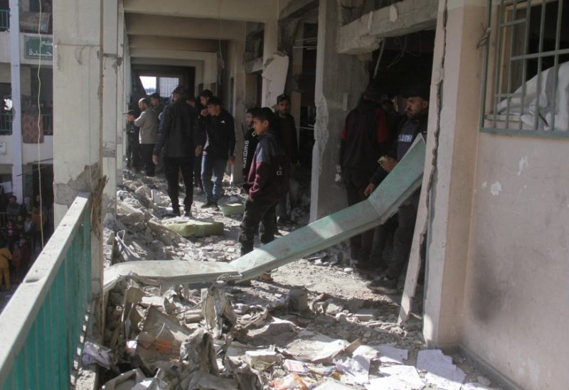 فلسطينيون يسيرون وسط الأنقاض، يتفقدون الأضرار التي لحقت بالمدرسة التي تأوي النازحين، في مدينة غزة، 14 ديسمبر/كانون الأول 2024. رويترز