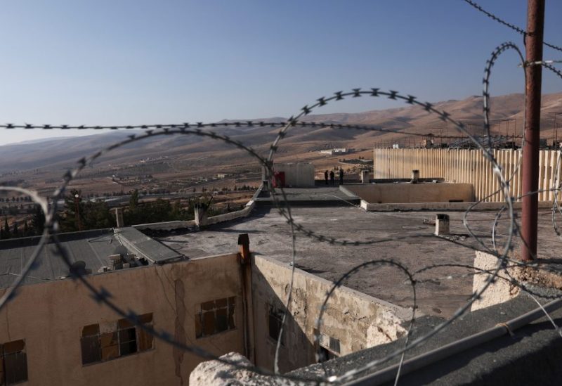 أفراد فرق الإنقاذ يقفون على سطح سجن صيدنايا في سوريا. رويترز