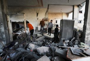 فلسطينيون يتفقدون مكان غارة جوية إسرائيلية على منزل في مدينة غزة، 27 ديسمبر/كانون الأول 2024. رويترز