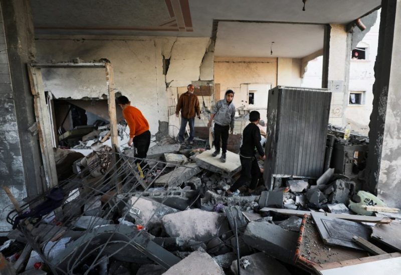 فلسطينيون يتفقدون مكان غارة جوية إسرائيلية على منزل في مدينة غزة، 27 ديسمبر/كانون الأول 2024. رويترز