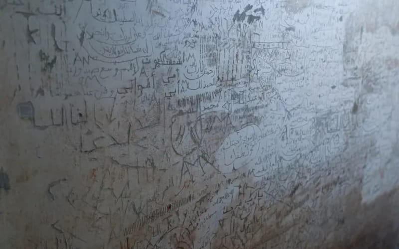 رسائل المعتقلين على جدران الزنازين في سجن المزة (الأناضول)