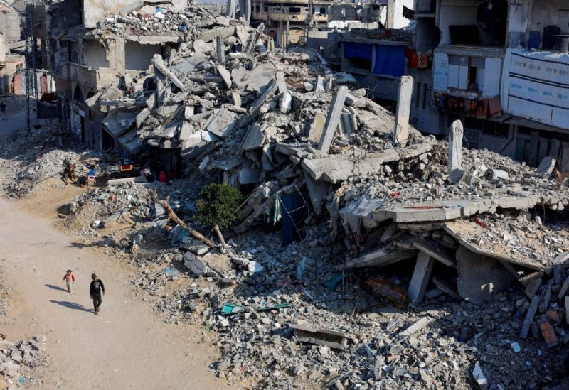 أطفال فلسطينيون يمشون أمام أنقاض المنازل المدمرة جراء غارات إسرائيلية سابقة، جنوب قطاع غزة، 7 يناير/كانون الثاني 2025. رويترز