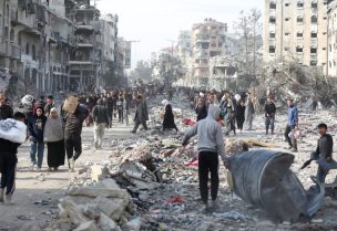 نازحون فلسطينيون يسيرون بين الأنقاض أثناء محاولتهم العودة إلى منازلهم في شمال قطاع غزة. رويترز