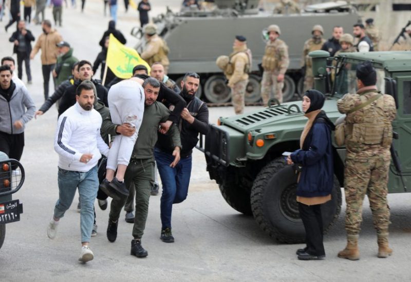 رجل يحمل شخصًا مصابًا بالقرب من قرية كفركلا جنوب لبنان. رويترز