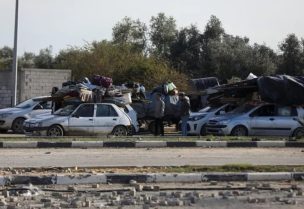 غزيون في شارع صلاح الدين ينتظرون السماح بالعودة لمنازلهم شمالي القطاع (الأناضول)