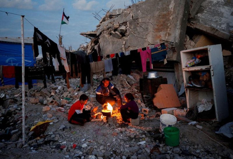فلسطينيون يتجمعون حول أنقاض المباني التي دمرت خلال الهجوم الإسرائيلي في شمال غزة. رويترز