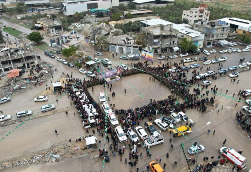 أشخاص ومقاتلون فلسطينيون من حركة حماس يتجمعون عند إطلاق سراح أسيرين من قبل مقاتلي حماس الفلسطينية في رفح جنوب قطاع غزة، 22 فبراير/شباط 2025. رويترز