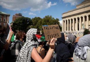 متظاهرة مؤيدة للفلسطينيين تحمل لافتة مكتوب عليها ”فلسطين ستعيش فلسطين إلى الأبد“، في حرم جامعة كولومبيا في نيويورك. رويترز