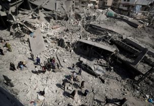 فلسطينيون يتفقدون موقع غارة إسرائيلية على مبنى سكني في جباليا شمال قطاع غزة في 18 مارس/آذار 2025. رويترز