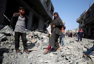 فلسطينيون يتفقدون موقع غارة إسرائيلية على مبنى سكني في جباليا. رويترز