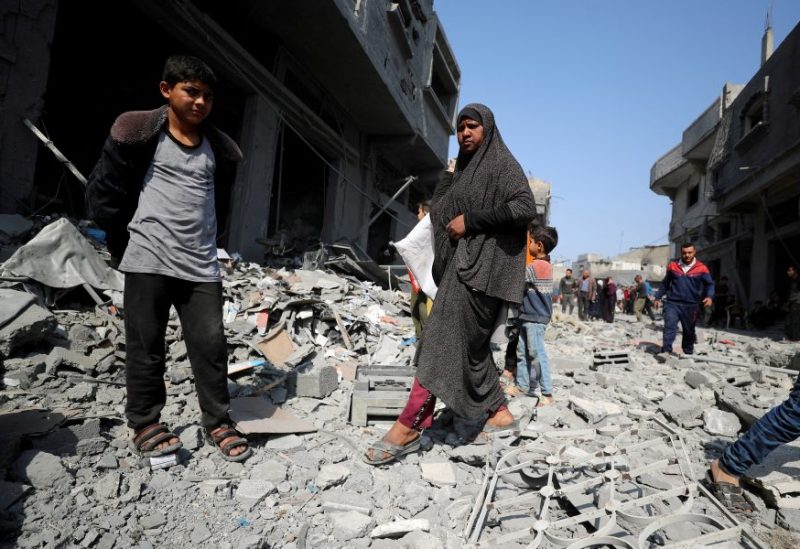 فلسطينيون يتفقدون موقع غارة إسرائيلية على مبنى سكني في جباليا. رويترز