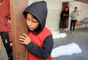طفل يقف بالقرب من جثث الفلسطينيين الذين استشهدوا في الغارات الإسرائيلية، المستشفى الأهلي العربي المعمداني في مدينة غزة، 26 مارس/آذار 2025. رويترز