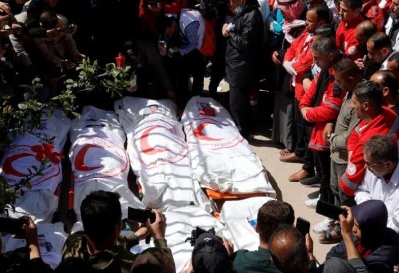فلسطينيون يشيعون 14 شهداء من الدفاع المدني والهلال الأحمر بخانيونس (رويترز)