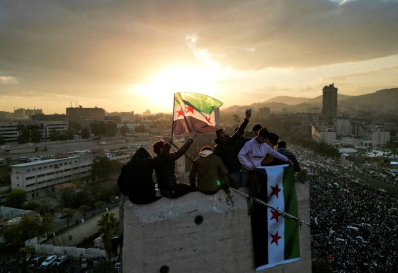 أشخاص يلوحون بالأعلام السورية خلال الاحتفالات في ساحة الأمويين، بعد الإطاحة بالرئيس السوري المخلوع بشار الأسد، في دمشق، سوريا، 20 ديسمبر/كانون الأول 2024. رويترز