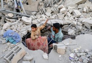 فلسطينيون يتفقدون موقع غارة إسرائيلية على منزل في خان يونس جنوب قطاع غزة في 22 أبريل/نيسان 2025. رويترز