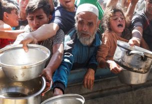 فلسطينيون ينتظرون الحصول على الطعام المطبوخ من قبل مطبخ خيري في خان يونس. رويترز