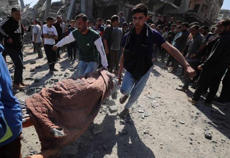 فلسطينيون يحملون جثة شهيد أثناء بحثهم عن شهداء في موقع غارة إسرائيلية على منزل في جباليا شمال قطاع غزة في 2 مايو/أيار 2025. رويترز