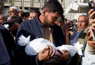 رجل يحمل جثة طفل أثناء مشاركته في جنازة فلسطينيين استشهدوا في الغارات الإسرائيلية في خان يونس، جنوب قطاع غزة، 3 مايو/أيار 2025. رويترز