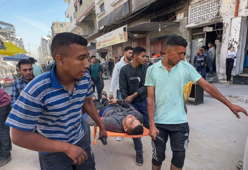 فلسطينيون يحملون مصابًا بعد غارة جوية إسرائيلية في مدينة غزة، 7 مايو/أيار 2025. رويترز