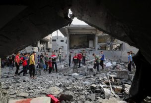 فلسطينيون يتفقدون موقع غارة إسرائيلية على منزل في جباليا، شمال قطاع غزة، 18 مايو/أيار 2025. رويترز