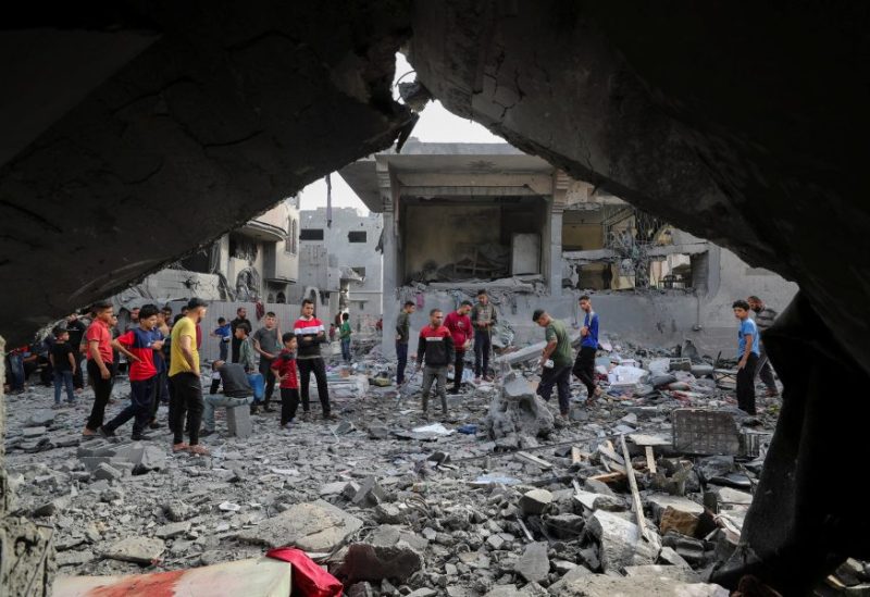 فلسطينيون يتفقدون موقع غارة إسرائيلية على منزل في جباليا، شمال قطاع غزة، 18 مايو/أيار 2025. رويترز